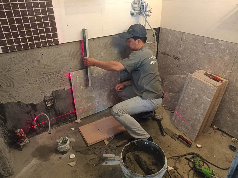 衛(wèi)生間貼磚施工：施工工藝流程; 基層處理--抹底子灰--彈線排磚--侵磚--鑲貼--擦縫--交工驗(yàn)收 用一比三的水泥砂漿打底,打底厚度5~~7mm，待底子灰干六七成干時(shí)候，按圖紙要求，進(jìn)行彈線，排磚。立好皮數(shù)桿，排磚形式有主要兩種直縫和錯(cuò)縫。當(dāng)?shù)孛嬗蟹核臅r(shí)候，注意安排好泛水。侵泡瓷磚，時(shí)間不少于兩個(gè)小時(shí)，陰干通常是3~~5小時(shí)。瓷磚在鑲貼時(shí)候，瓷磚下口坐在八字尺或直尺上。鋪貼的方式有離縫和無縫。鑲貼瓷磚從陽角開始，自下向上貼，瓷磚背面刀灰，貼上用力壓，用鏟刀木柄輕輕敲打，鋪貼時(shí)候砂漿飽滿，缺灰重貼，不得塞灰，貼6~~8塊，用靠尺校正。水管處先鋪周圍整塊磚，后鋪異型磚。最后擦縫。